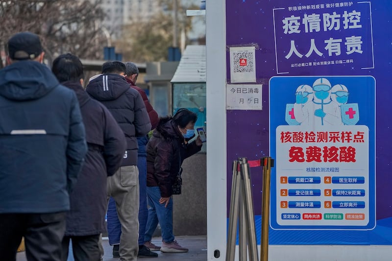 北京一名妇女2022年12月7日在准备检测核酸时出示健康码(美联社)