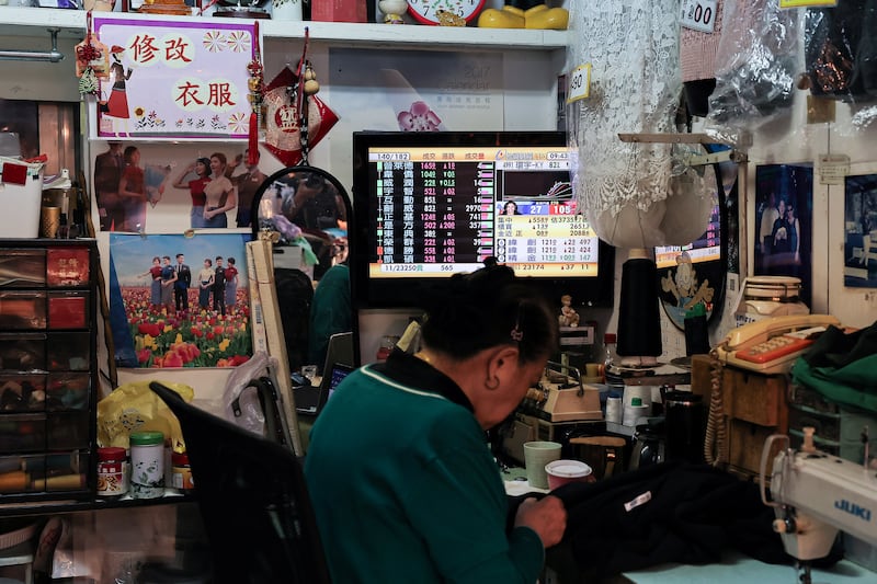 A person sits near a TV showing a live broadcast of the US election on the morning news at a store in Taipei, Taiwan November 6, 2024. REUTERS/Ann Wang