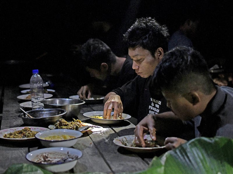 Members of Bamar People's Liberation Army eat  dinner in territory belonging to the Karen National Liberation Army in Karen State, Myanmar, February 17, 2024.