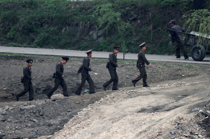 신의주에서 북한 군인들이 압록강 둑을 따라 순찰을 돌고 있다.
