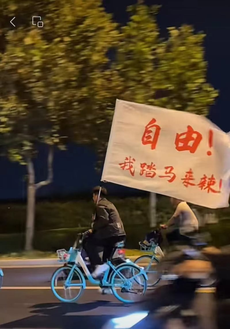 大学生夜骑队伍中,打出“自由”等标语。(网络视频截图/记者乾朗提供)