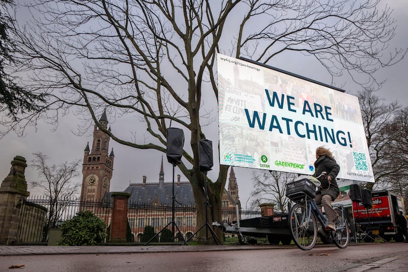 Activists protest outside the International Court of Justice, left, in The Hague, Netherlands, as it opens hearings into what countries worldwide are legally required to do to combat climate change and help vulnerable nations fight its devastating impact, Monday, Dec. 2, 2024.